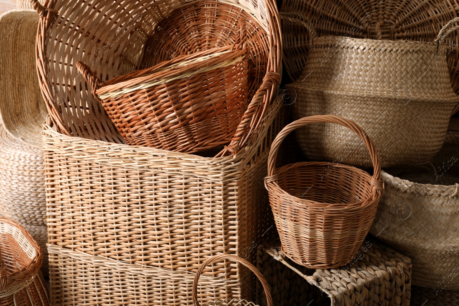 Photo of Many different wicker baskets made of natural material as background, closeup