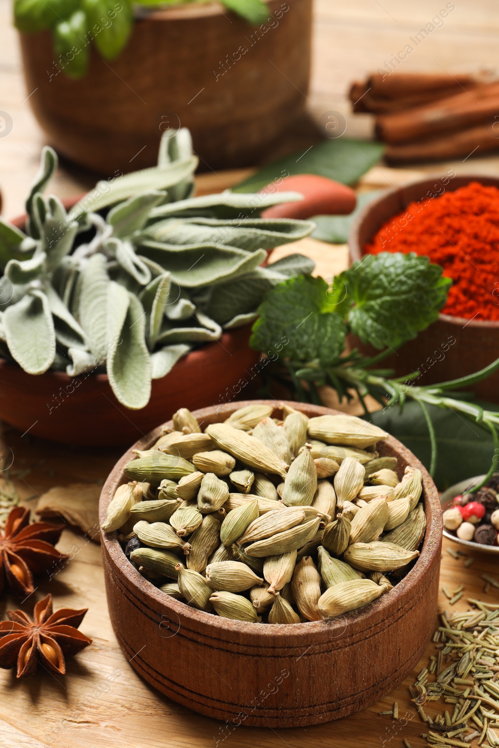 Photo of Different herbs and spices on wooden table, closeup