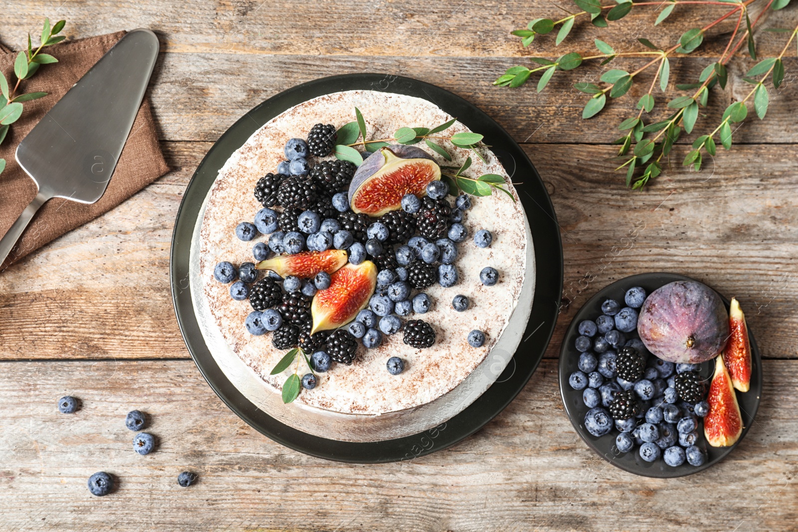 Photo of Delicious homemade cake with fresh berries served on wooden table, flat lay