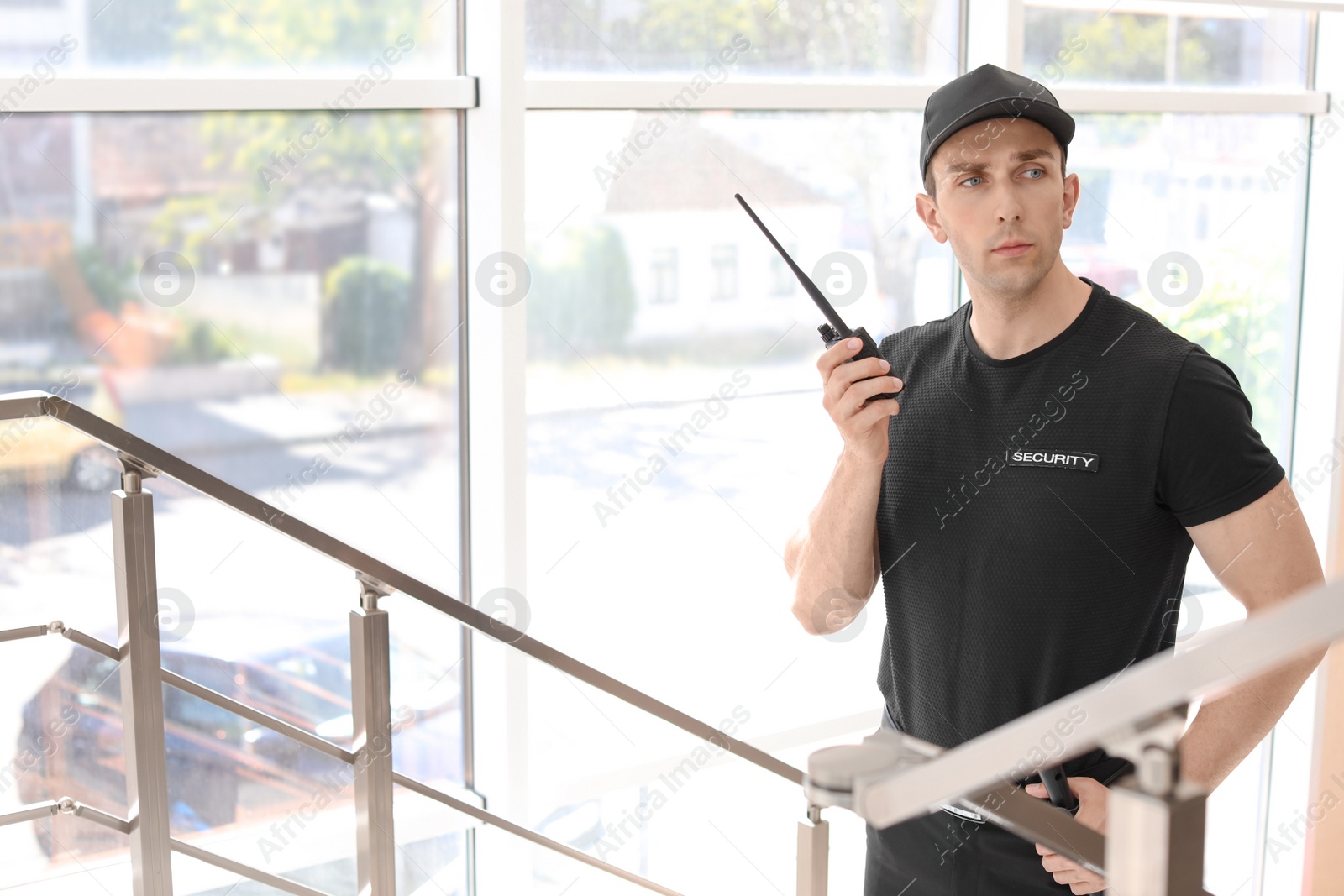 Photo of Male security guard with portable radio transmitter indoors