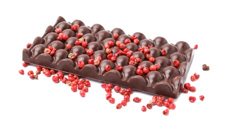 Dark chocolate bar with red peppercorns isolated on white