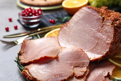 Delicious ham served for festive dinner on grey table, closeup