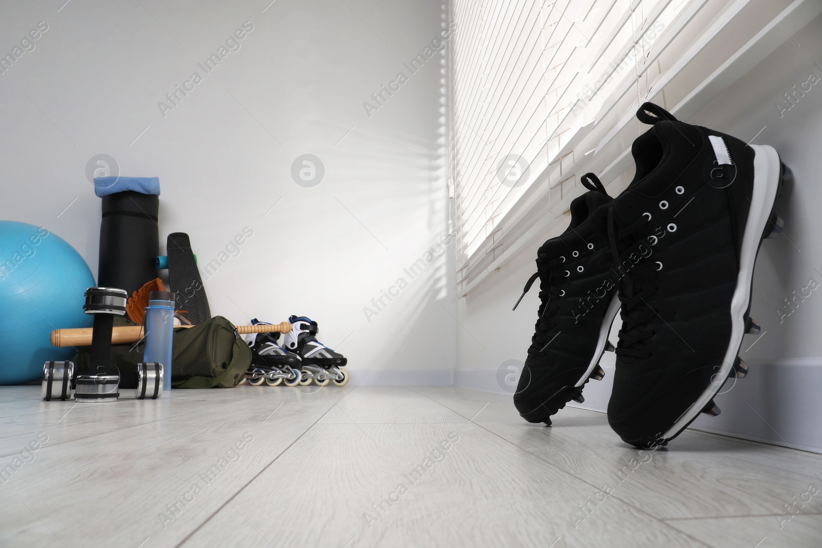 Photo of Black snickers and different sports equipment indoors