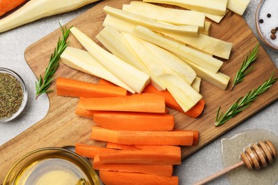 Flat lay composition with parsnips, carrots and other products on light grey table