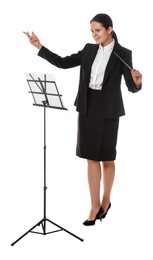 Happy young conductor with baton and note stand on white background