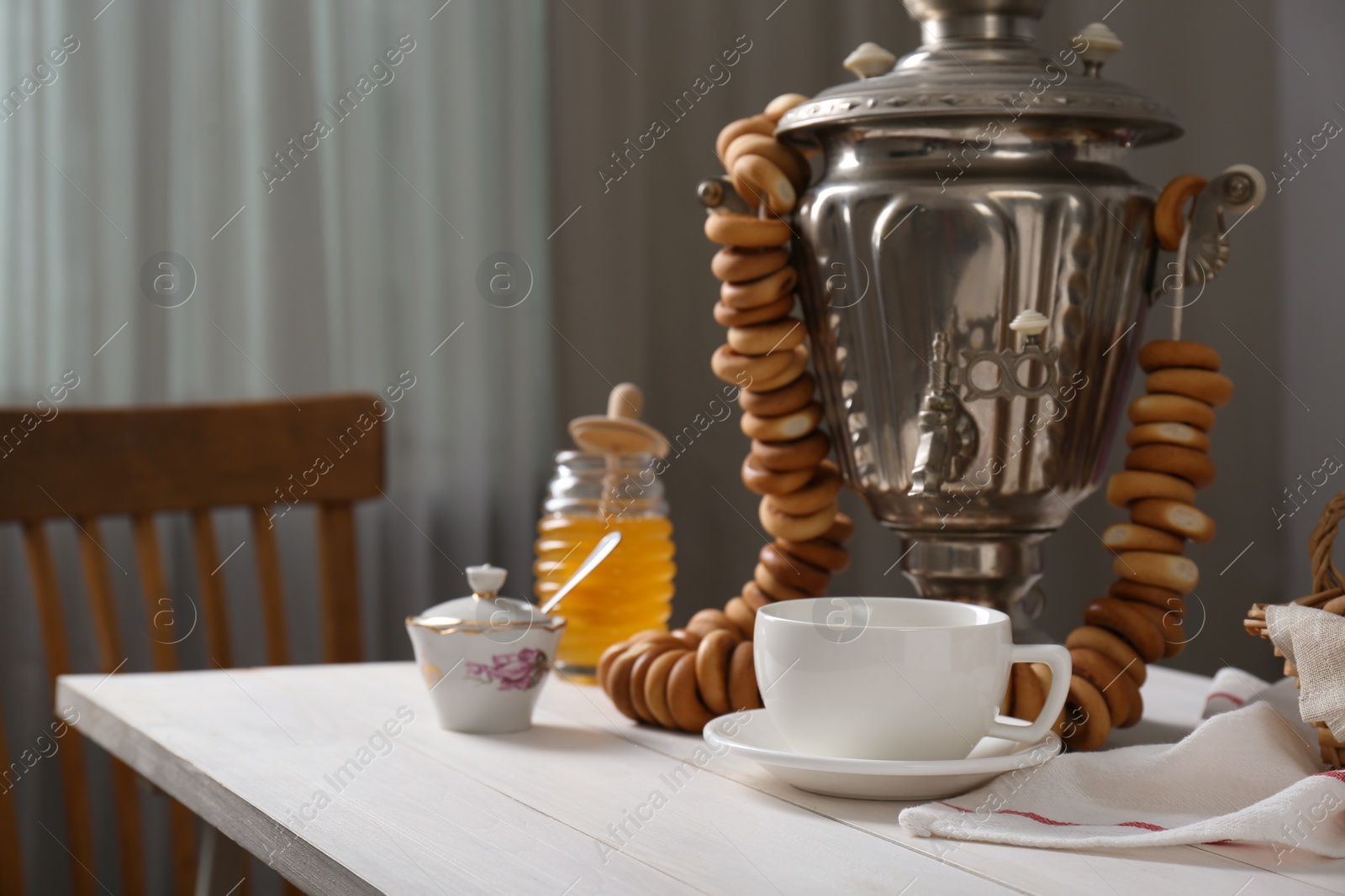 Photo of Composition with delicious ring shaped Sushki (dry bagels) and tea on white wooden table indoors, space for text