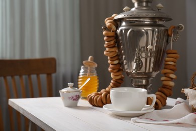 Photo of Composition with delicious ring shaped Sushki (dry bagels) and tea on white wooden table indoors, space for text