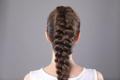 Photo of Woman with braided hair on grey background, back view