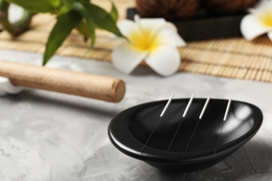 Bowl with needles for acupuncture on dark table