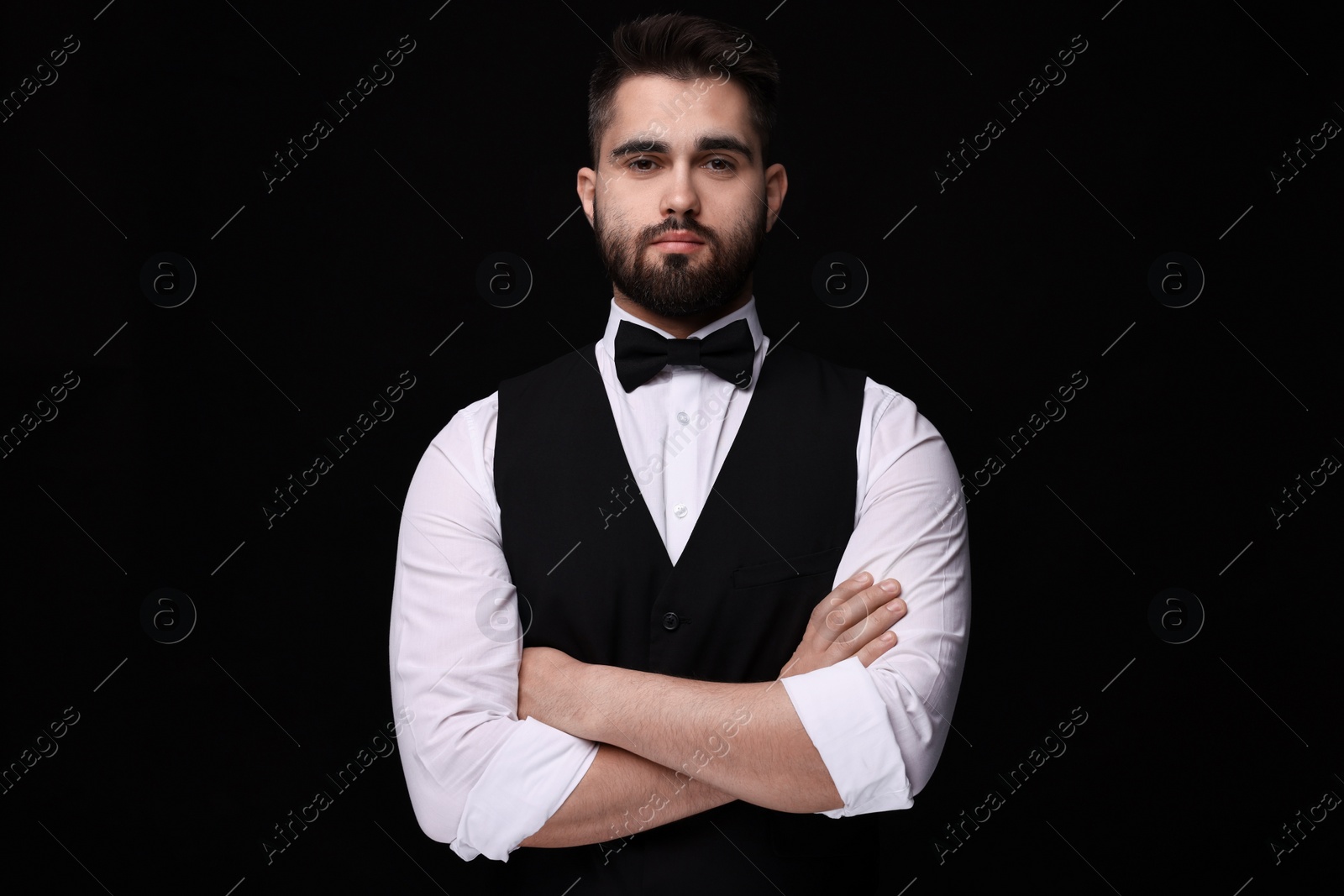 Photo of Portrait of handsome man in shirt and bow tie on black background