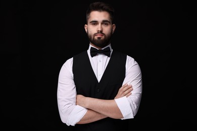 Photo of Portrait of handsome man in shirt and bow tie on black background