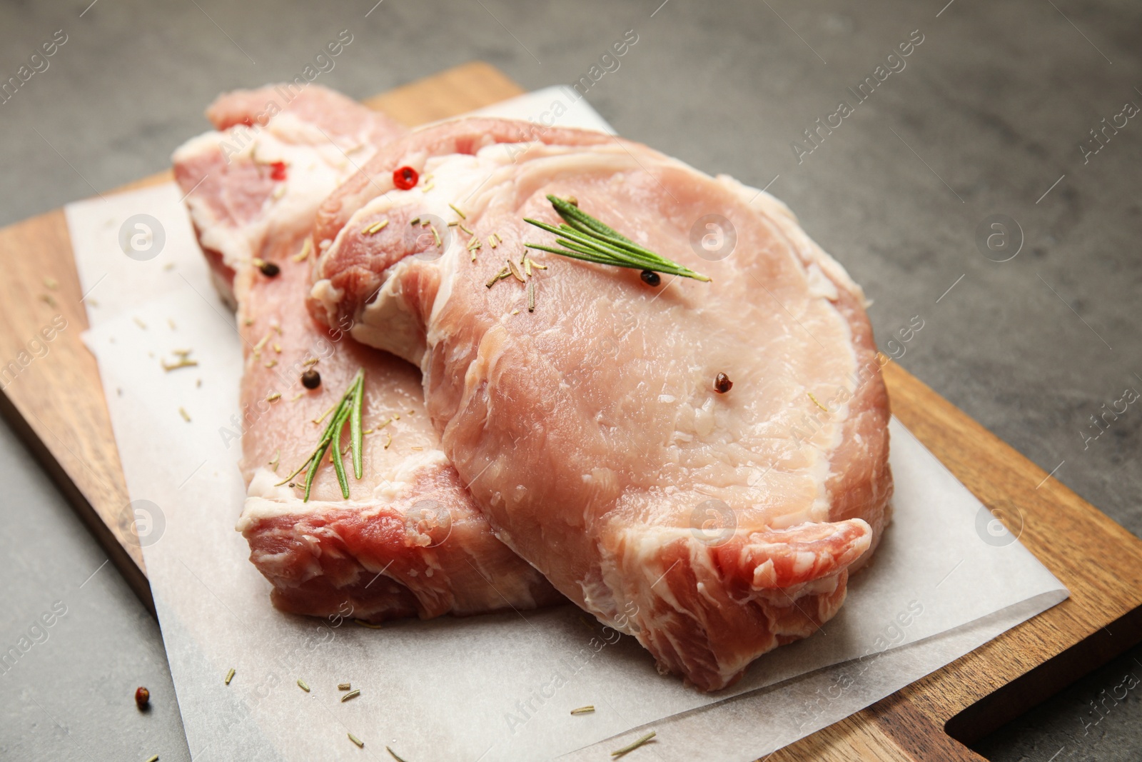 Photo of Fresh raw beef cut with spices on grey table, closeup