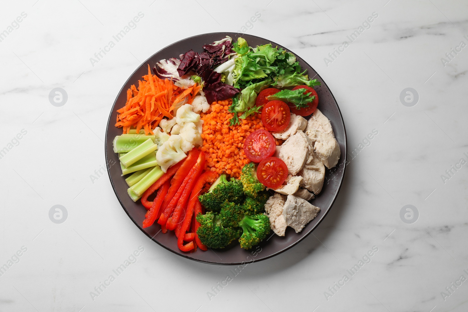 Photo of Balanced diet and healthy foods. Plate with different delicious products on white marble table, top view