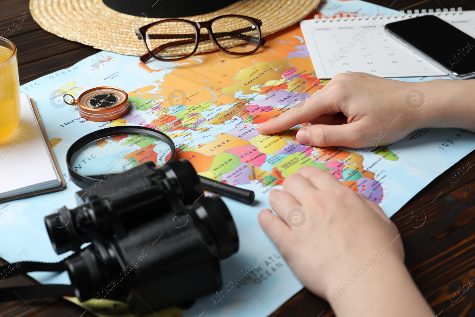 Photo of Woman with world map at table, closeup. Travel during summer vacation