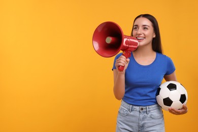 Happy fan with soccer ball using megaphone on yellow background, space for text