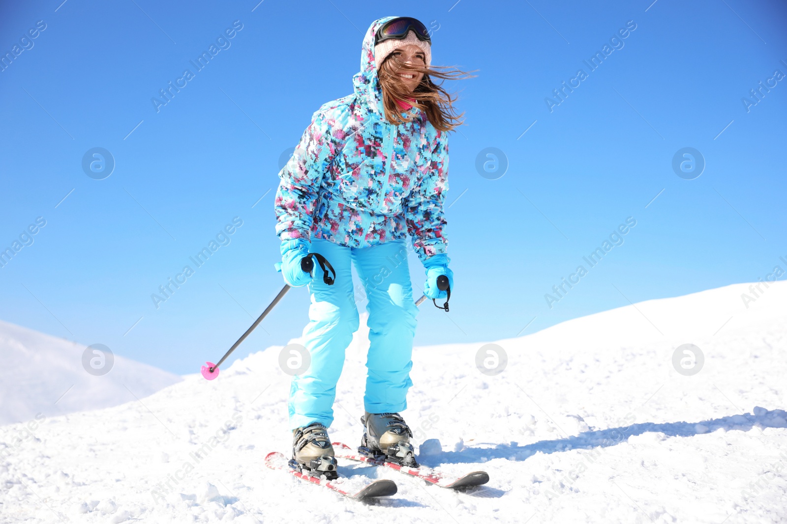 Photo of Happy young woman skiing outdoors. Winter vacation