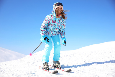 Photo of Happy young woman skiing outdoors. Winter vacation