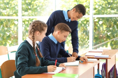 Teenage students in classroom. Stylish school uniform