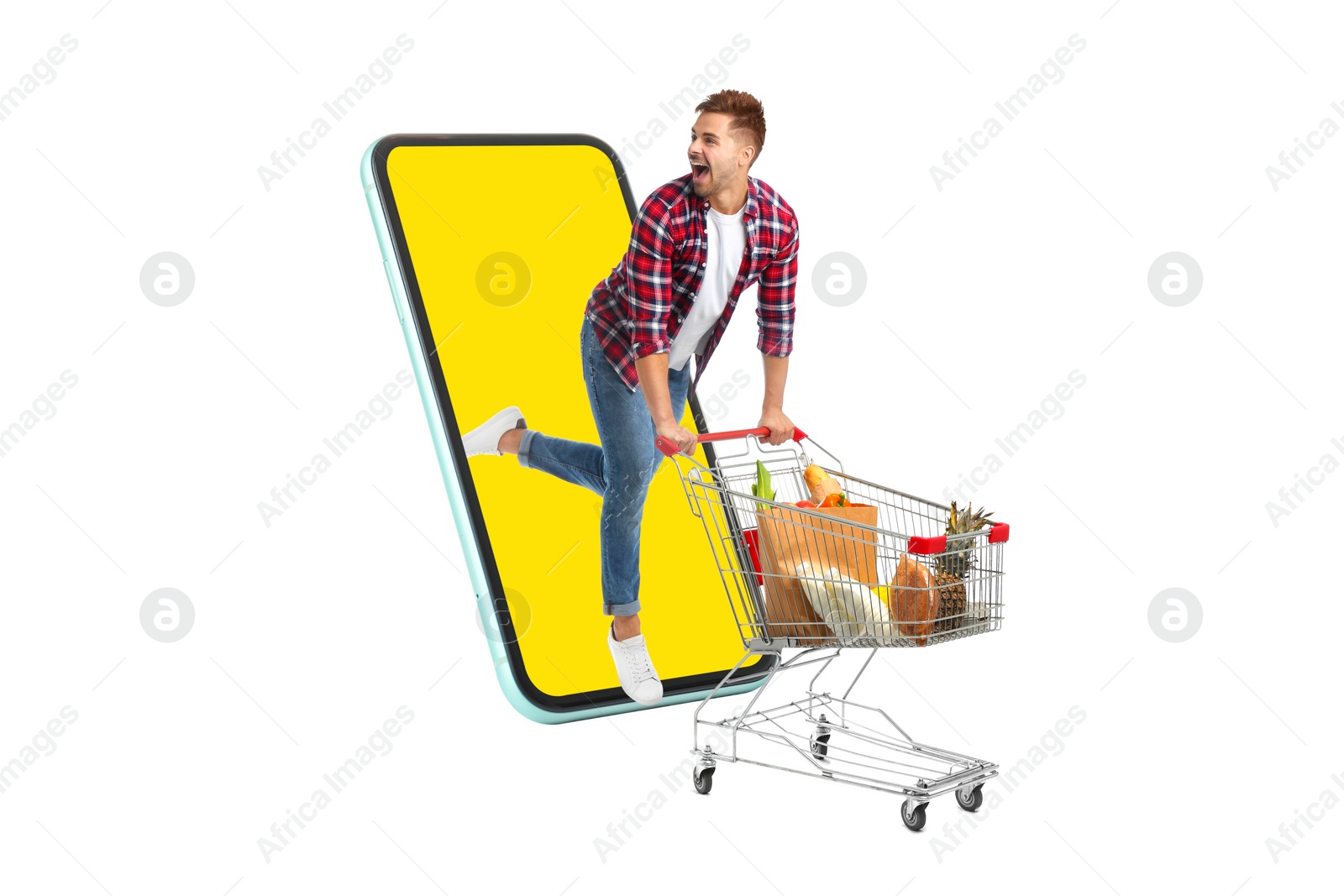 Image of Grocery shopping via internet. Excited man with shopping cart full of products running out of huge smartphone on white background