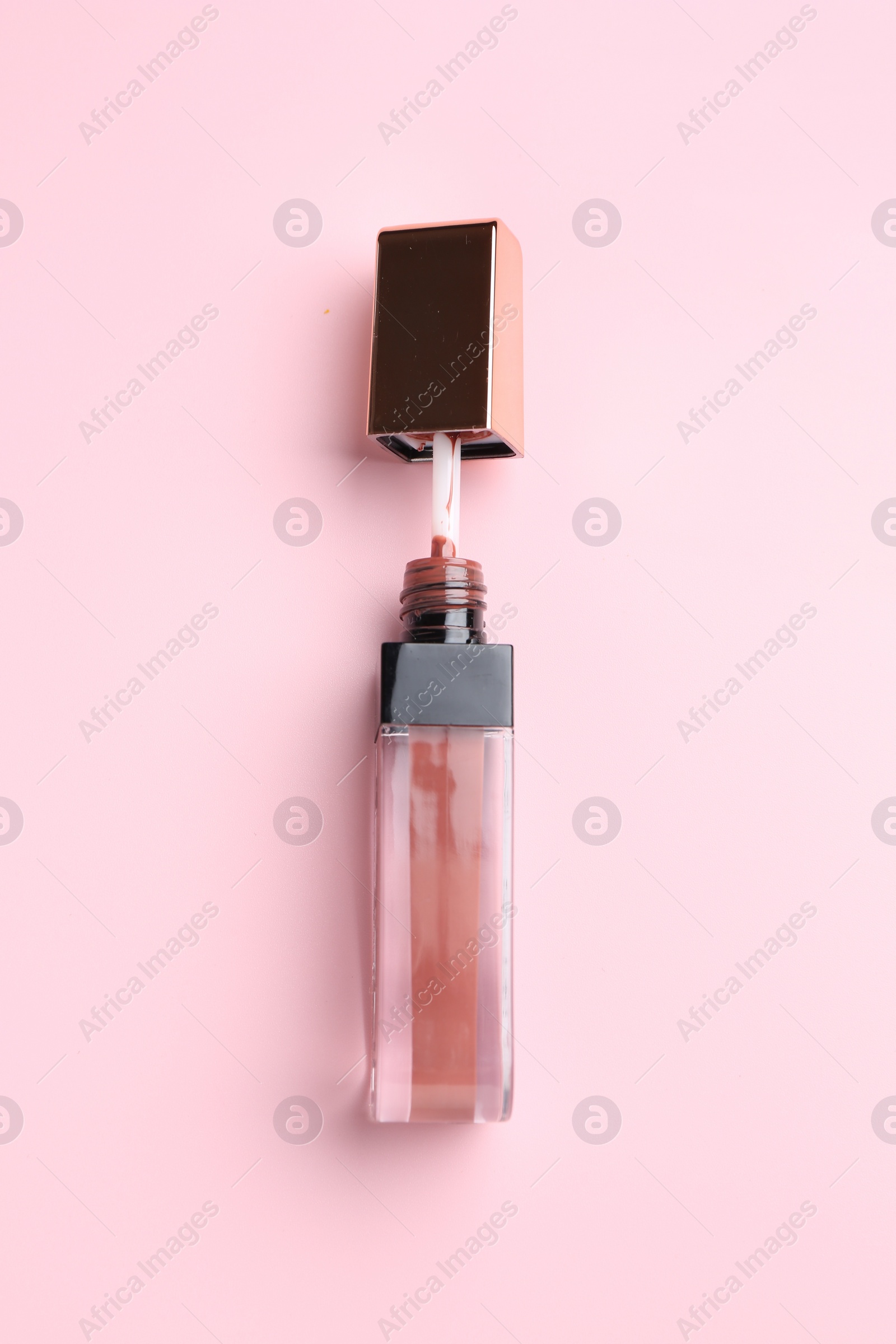 Photo of Bright lip gloss on pink background, top view