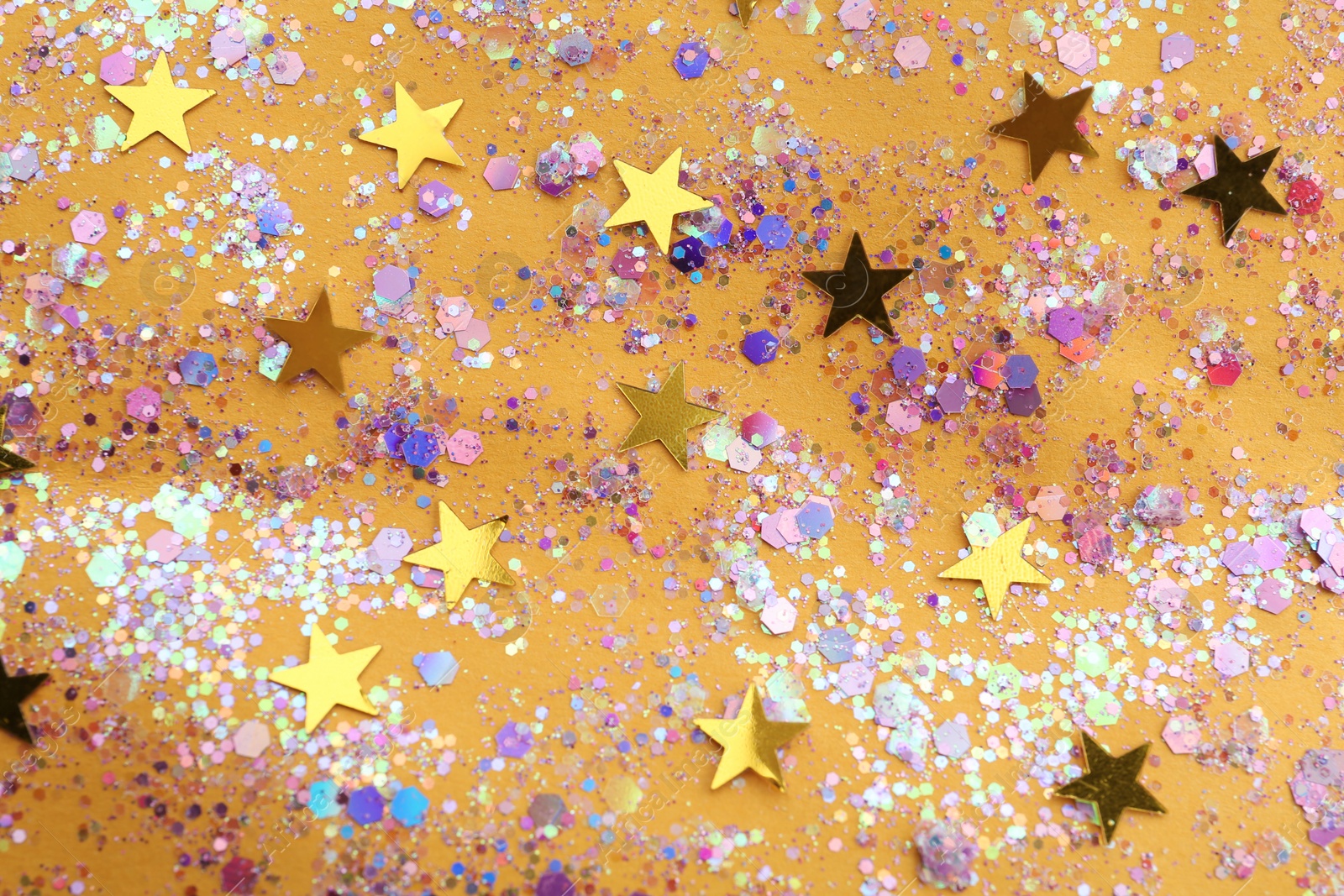 Photo of Shiny glitter on yellow background, flat lay