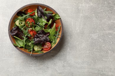 Tasty fresh vegetarian salad on grey table, top view. Space for text