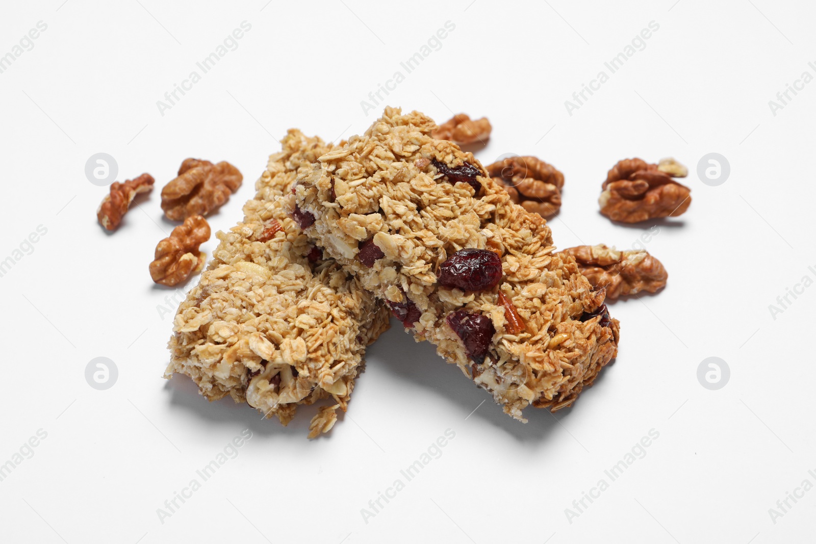 Photo of Tasty granola bars and walnuts on white background