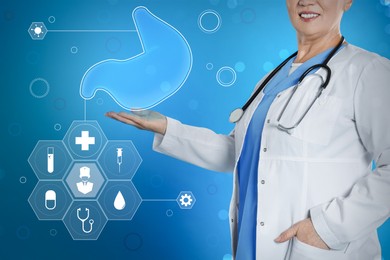 Gastroenterologist holding virtual image of stomach on turquoise background, closeup
