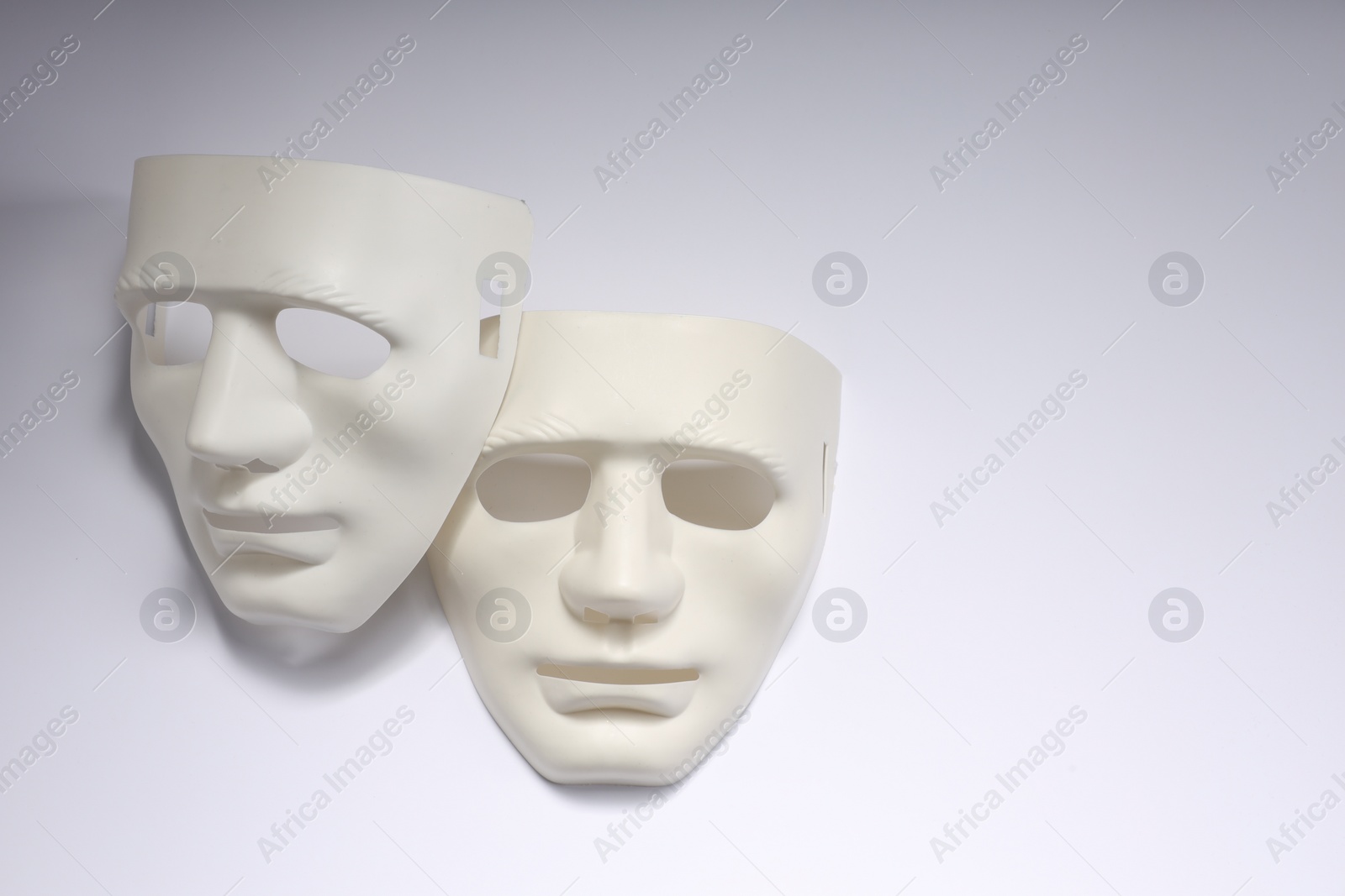 Photo of Theater arts. Two masks on white background, above view. Space for text