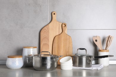 Photo of Set of different cooking utensils on grey countertop in kitchen