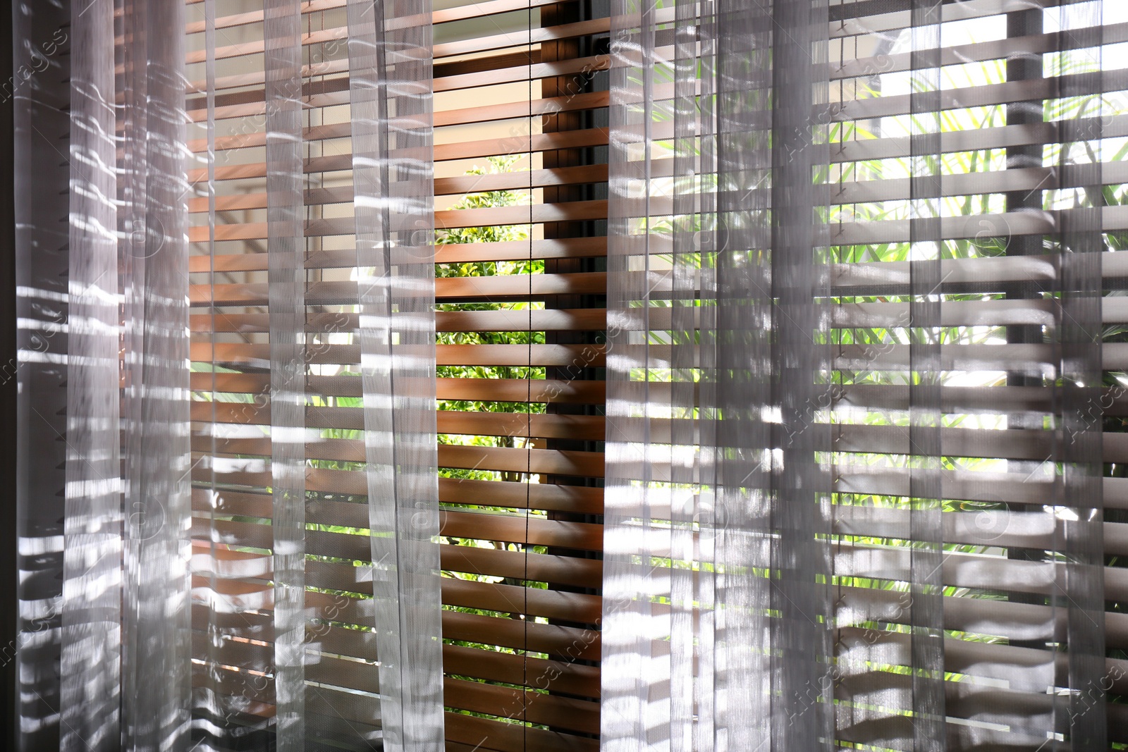 Photo of Window with beautiful curtains and blinds, closeup