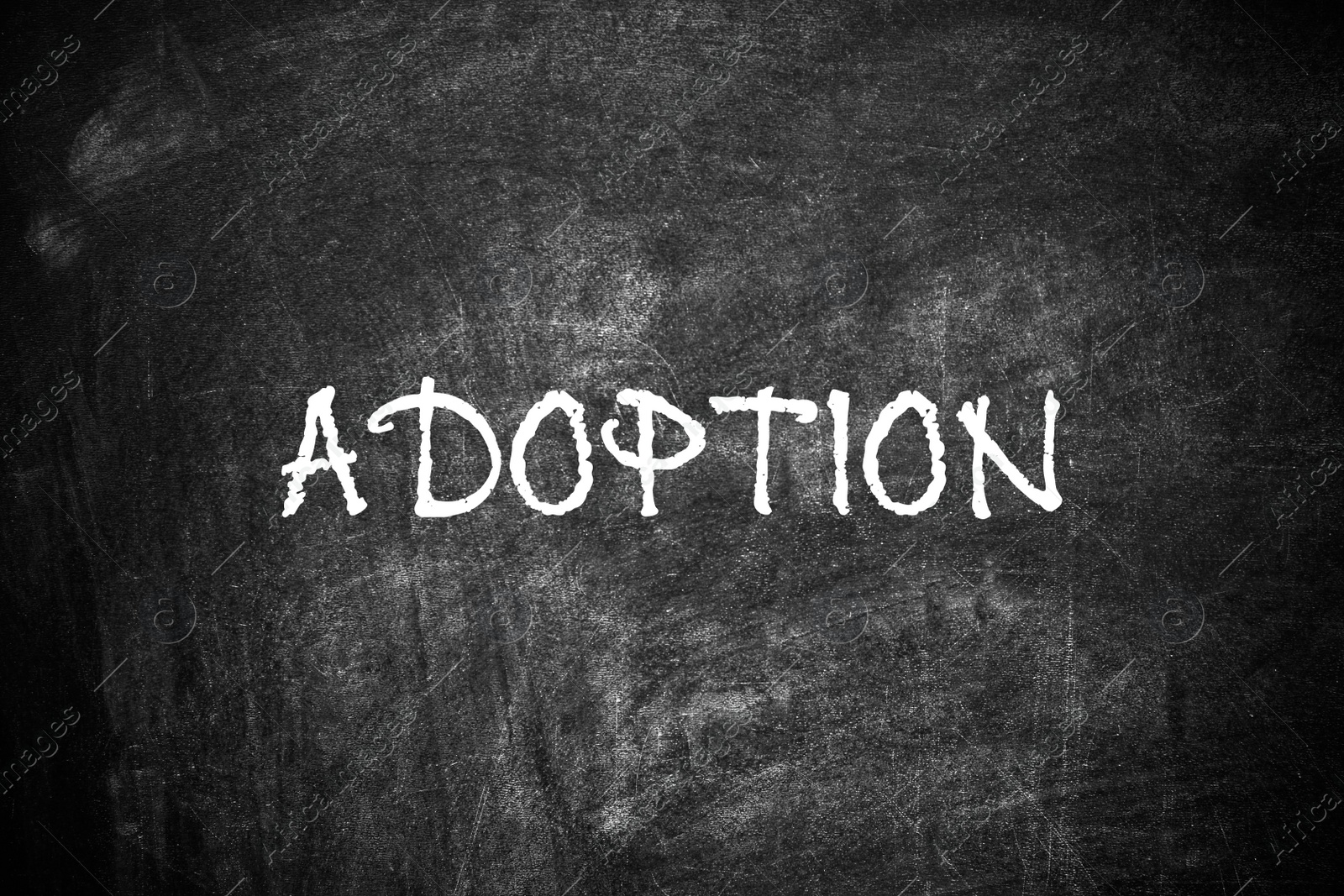 Image of Word ADOPT written with chalk on blackboard, top view. Family concept