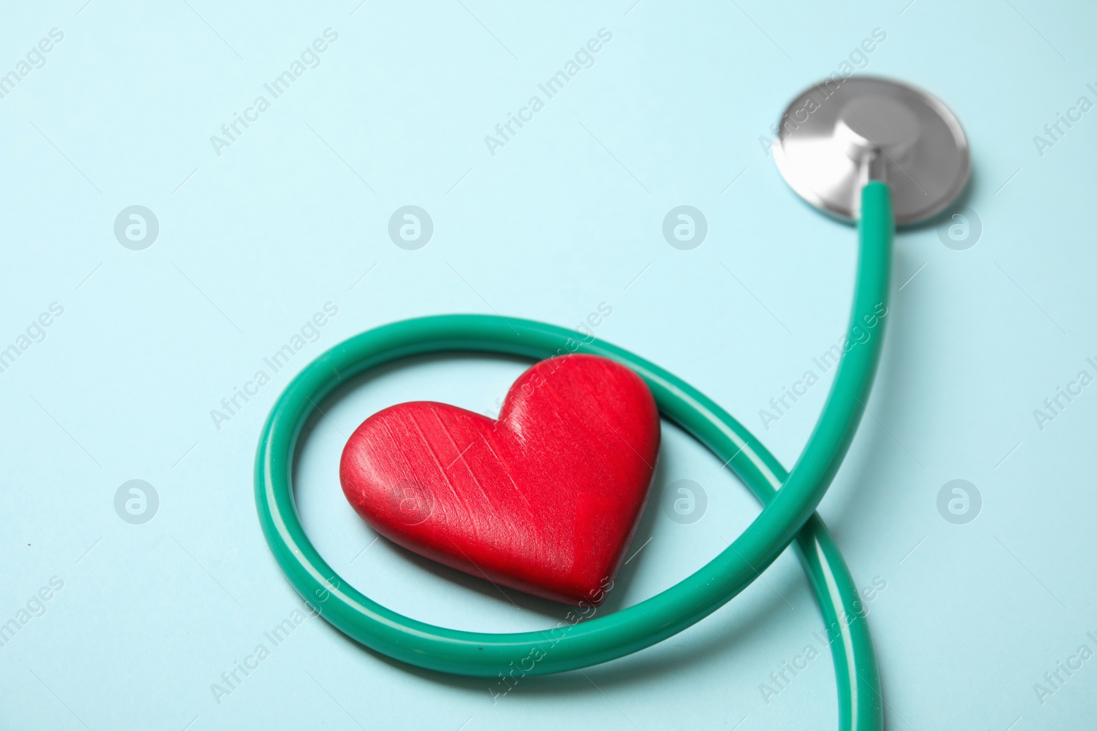 Photo of Stethoscope and red heart on color background. Cardiology concept