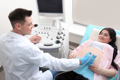 Young pregnant woman undergoing ultrasound scan in clinic