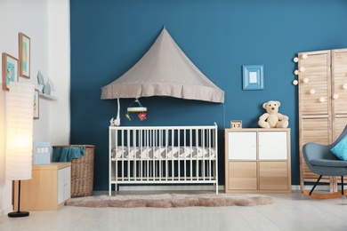 Photo of Stylish baby room interior with crib