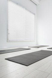 Photo of Spacious yoga studio with exercise mats, low angle view