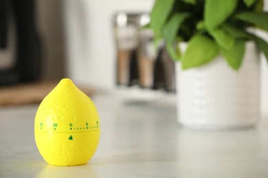 Kitchen timer in shape of lemon on white table indoors. Space for text