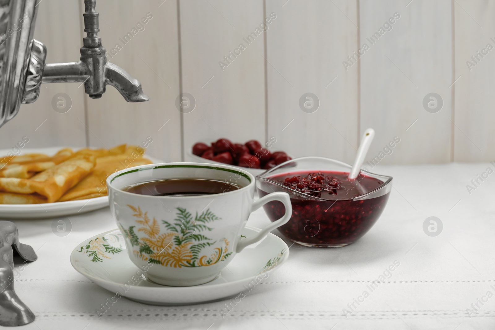 Photo of Cup of aromatic tea and treats on table. Space for text