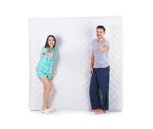 Photo of Young couple with comfortable mattress isolated on white