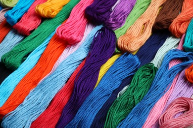 Photo of Different colorful embroidery threads as background, closeup