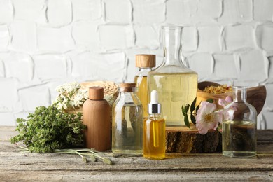 Photo of Aromatherapy. Different essential oils, herbs and flowers on wooden table