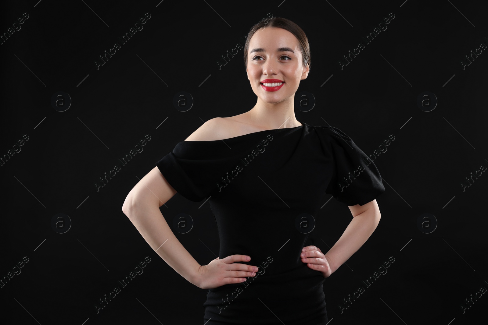 Photo of Beautiful young woman in elegant dress on black background