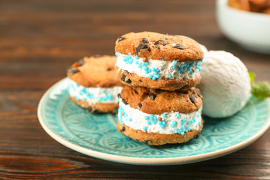 Photo of Sweet delicious ice cream cookie sandwiches on wooden table, closeup