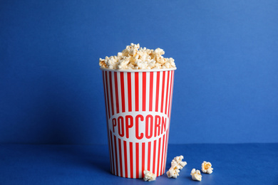 Photo of Tasty fresh pop corn on blue background