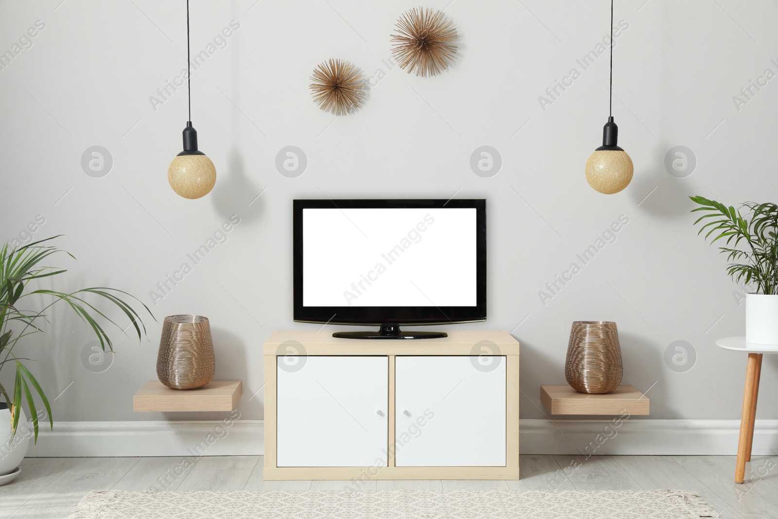 Photo of Modern TV set near white wall in living room