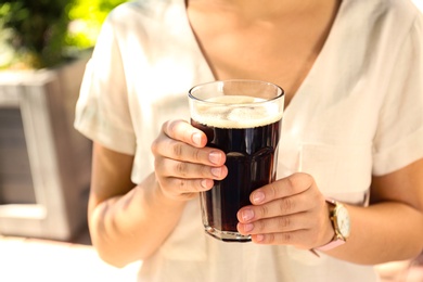 Photo of Young woman with cold kvass outdoors, closeup. Traditional Russian summer drink