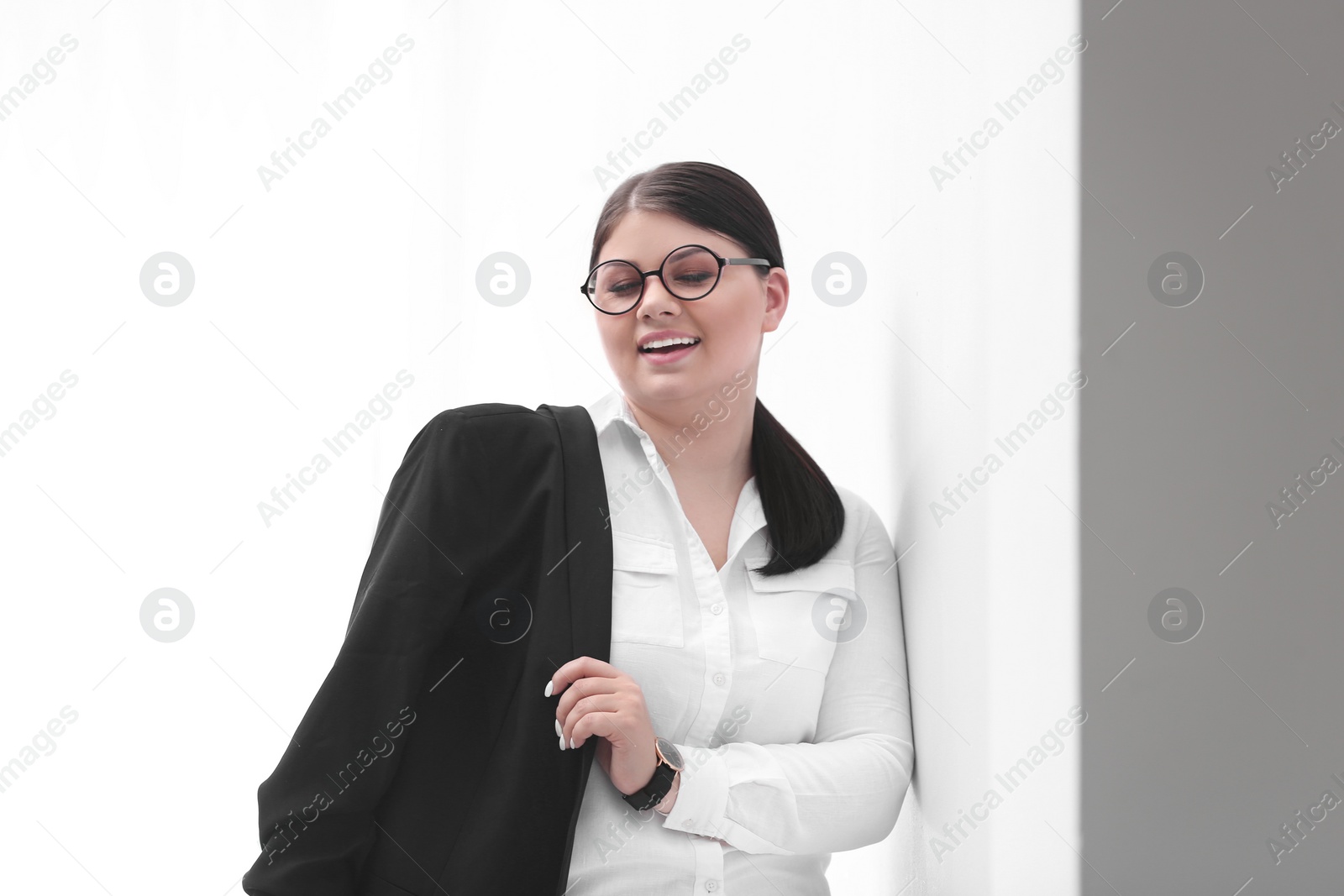 Photo of Beautiful overweight businesswoman posing on light background. Plus size model