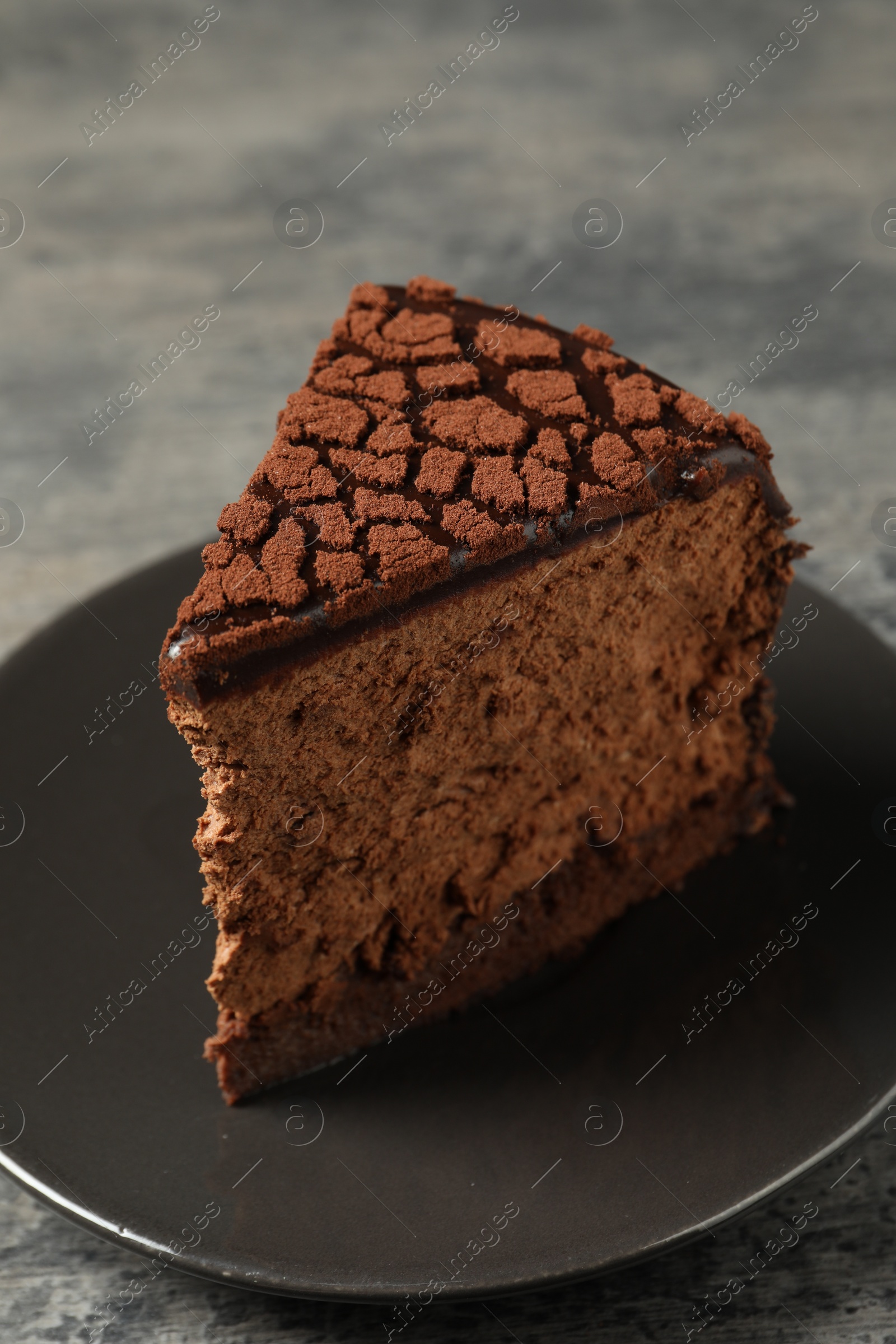 Photo of Piece of delicious chocolate truffle cake on table, closeup