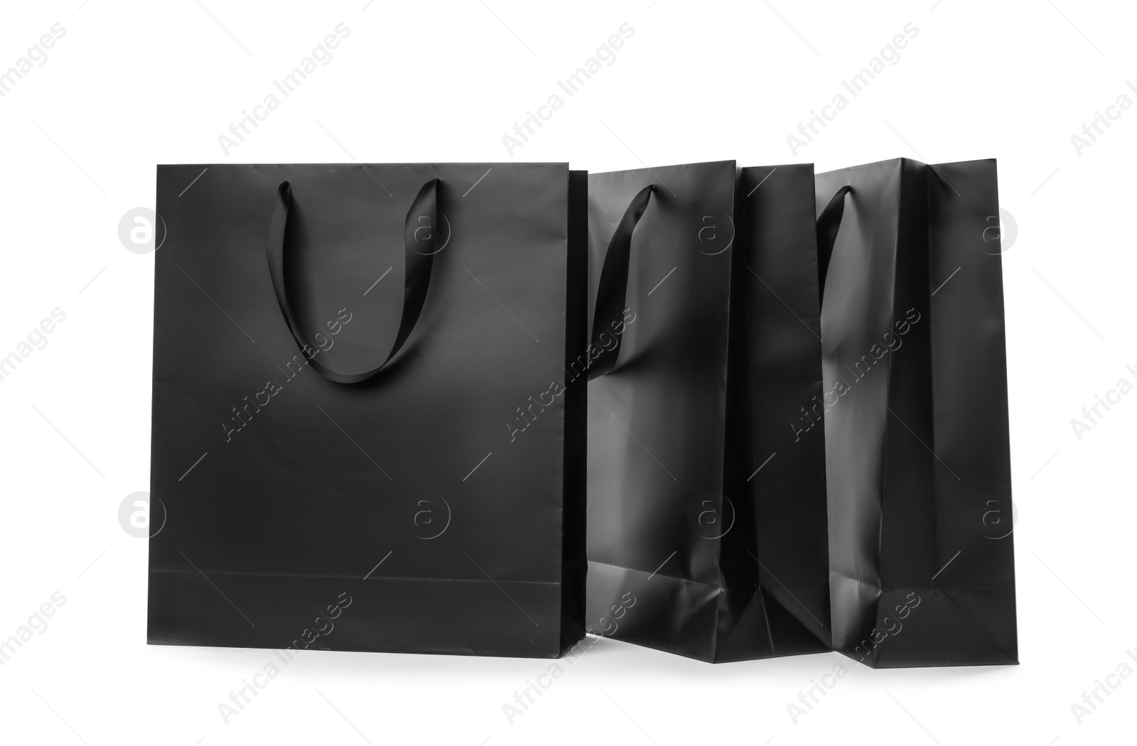 Photo of Paper shopping bags with ribbon handles on white background. Mockup for design