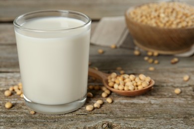 Glass with fresh soy milk and grains on wooden table, closeup